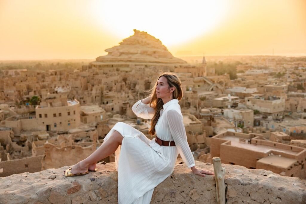 woman at sunset overlooking shali fortress siwa oasis egypt