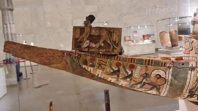 古代エジプトの木製の葬儀船の模型。精巧な人形とオールが描かれている。