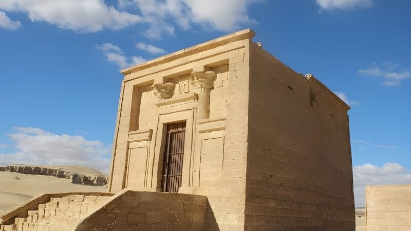 Ancient Egyptian temple entrance with massive stone columns in desert landscape