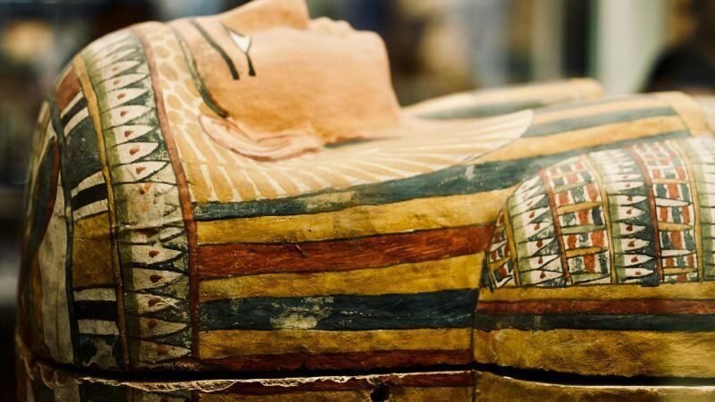 鮮やかな色彩で描かれた古代エジプトの石棺の蓋。詳細な象形文字と神々の姿が描かれている。
