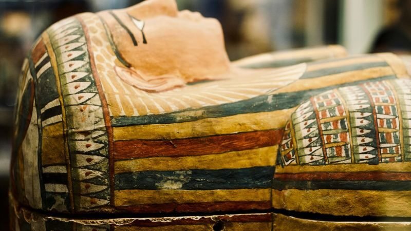 Vibrant painted ancient Egyptian sarcophagus lid with detailed hieroglyphs and deity figures