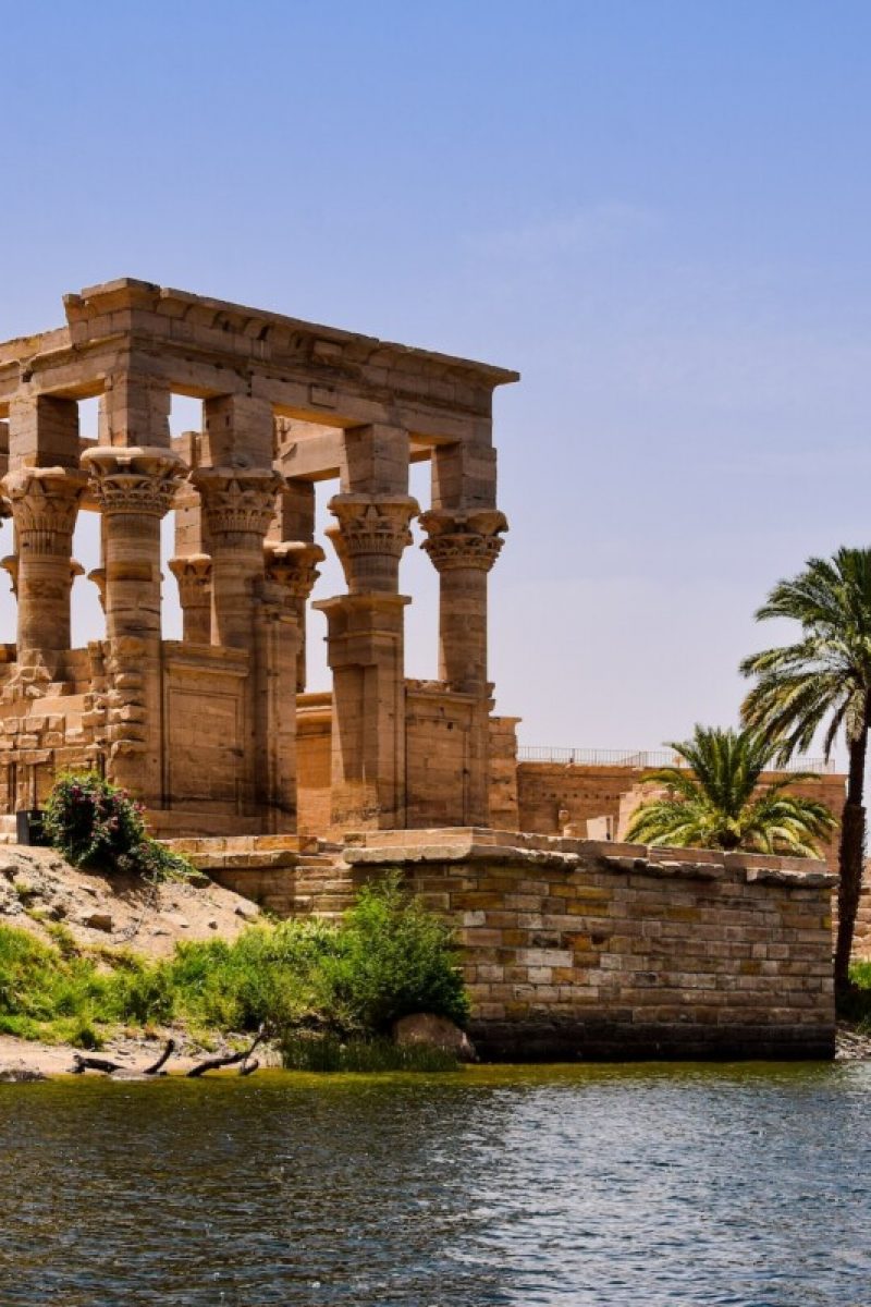 The iconic columns of the Temple of Philae against the backdrop of the Nile River.