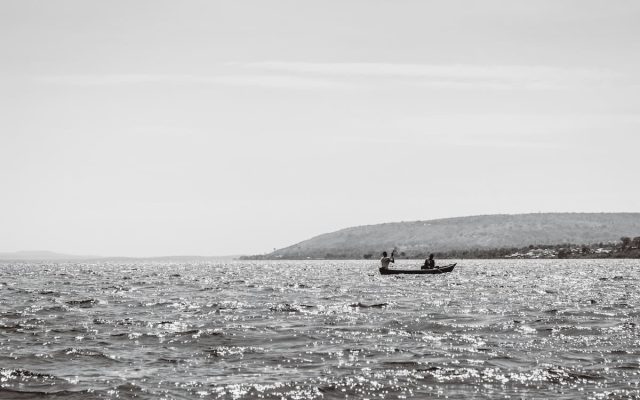 A black and white image of two people in a small boat on the glistening waters of Lake Nasser.